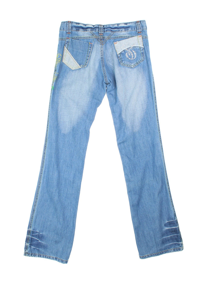 Y2K Embroidered Flared Jeans in blue colourway with multiple pockets, contrast stitching and floral detailing on the front.