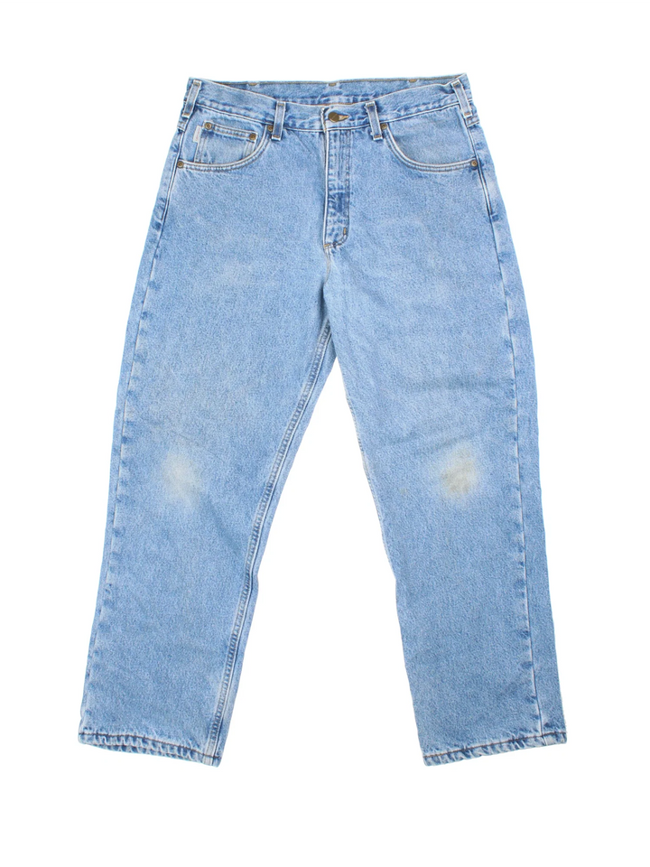 Carhartt Jeans in blue colourway with multiple pockets, plaid pattern lining, and the logo embroidered on the back.