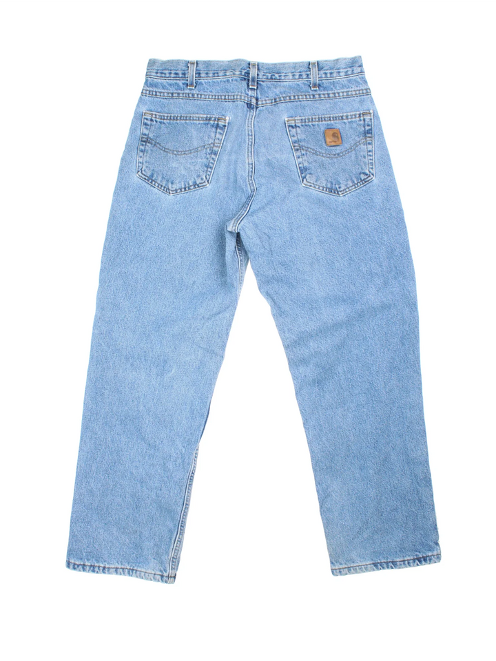 Carhartt Jeans in blue colourway with multiple pockets, plaid pattern lining, and the logo embroidered on the back.