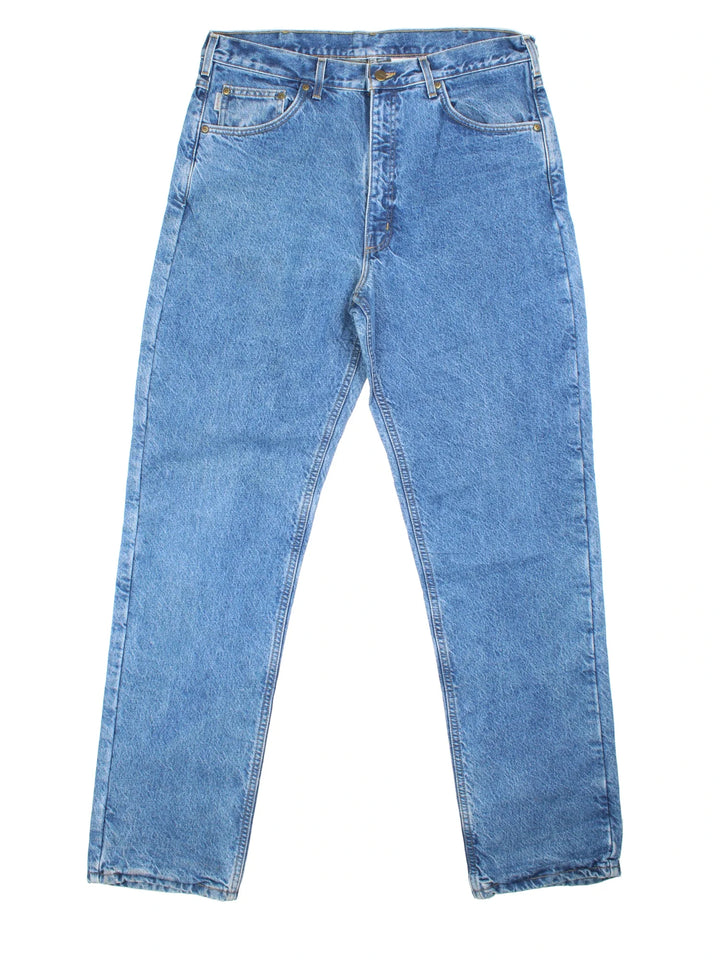 Carhartt Jeans in blue colourway with multiple pockets, plaid pattern lining, and the logo embroidered on the back.