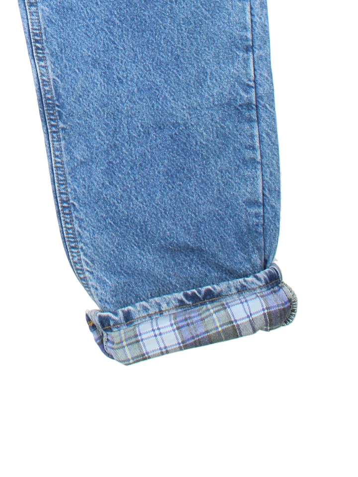 Carhartt Jeans in blue colourway with multiple pockets, plaid pattern lining, and the logo embroidered on the back.