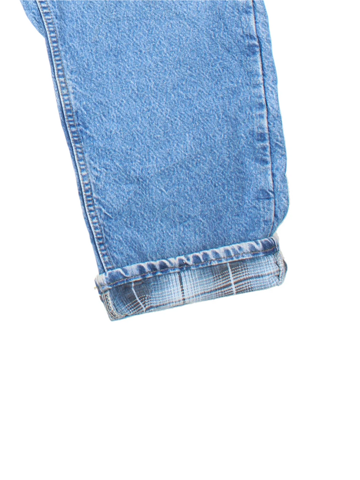 Carhartt Jeans in blue colourway with multiple pockets, plaid pattern lining, and the logo embroidered on the back.