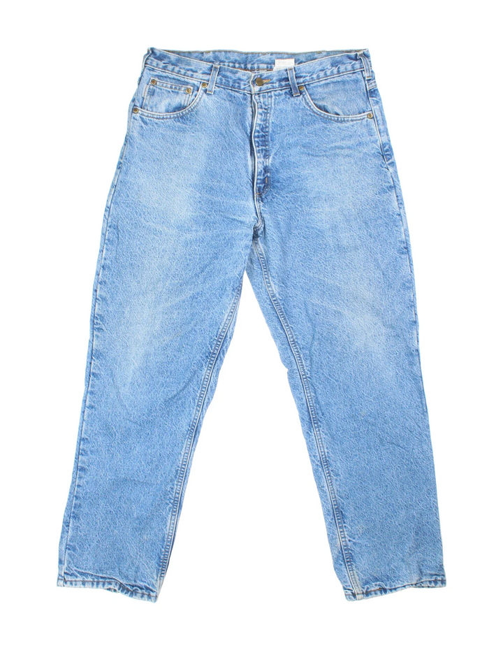 Carhartt Jeans in blue colourway with multiple pockets, plaid pattern lining, and the logo embroidered on the back.