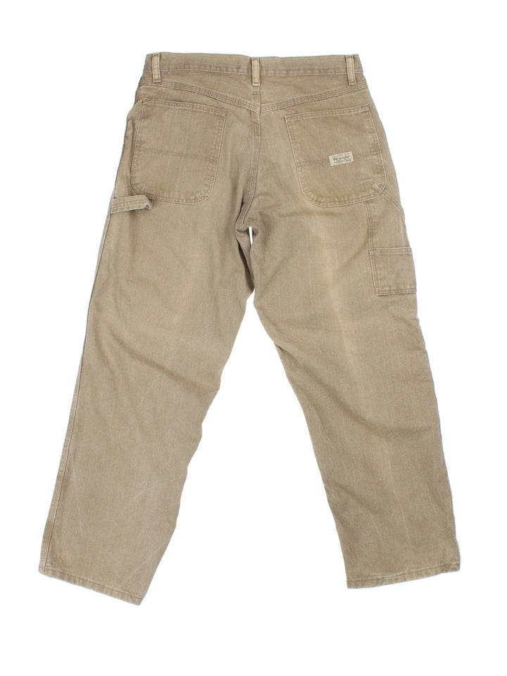 Wrangler Carpenter Jeans in brown colourway with multiple pockets and the logo embroidered on the back.