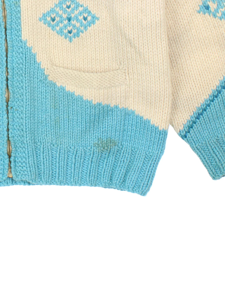 Vintage 80's Snowflake Cowichan Knitted Sweater in a tan and blue colourway with snowflake patterns all over, zip up closure and has double front pockets.