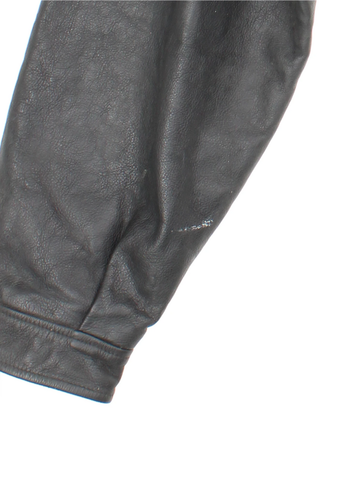 Vintage 1994 Disney Lion King Promo Leather Jacket in black. The jacket has a dagger collar, Lion King logo embroidered on the front panel and an interior pocket. The jacket is also lined with a quilted satin fabric. 