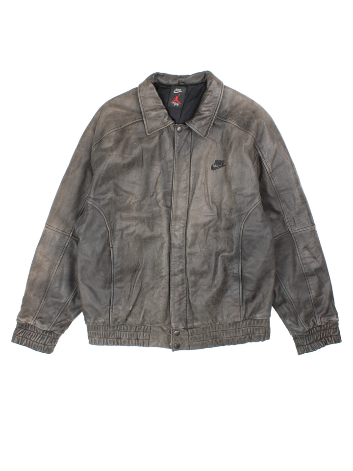 Vintage Nike Flight Air Jordan bomber jacket in brown. The jacket has the nike logo embroidered in black on the front, a large embroidered logo on the back, a zip to close and an interior pocket.  