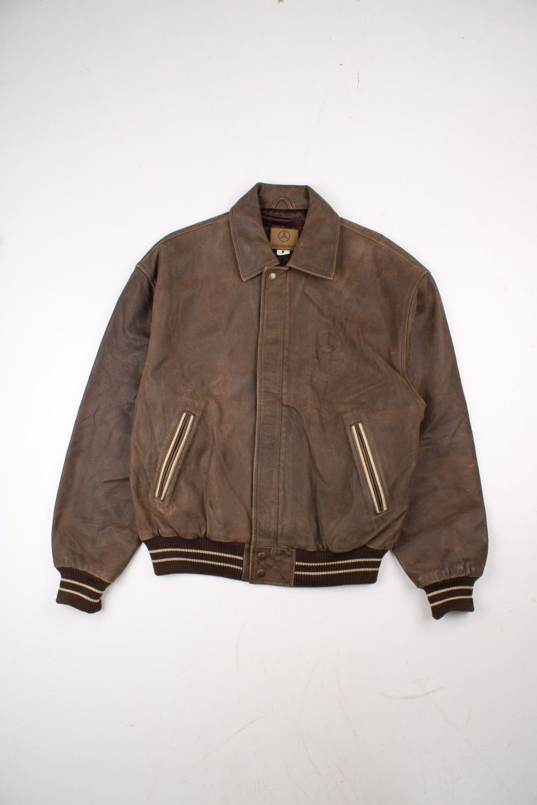 Vintage Mercedes Benz Leather Bomber Jacket in a brown colourway. Zip up fastening with side pockets, contrast cuffs/hem and embroidered branding on the front.