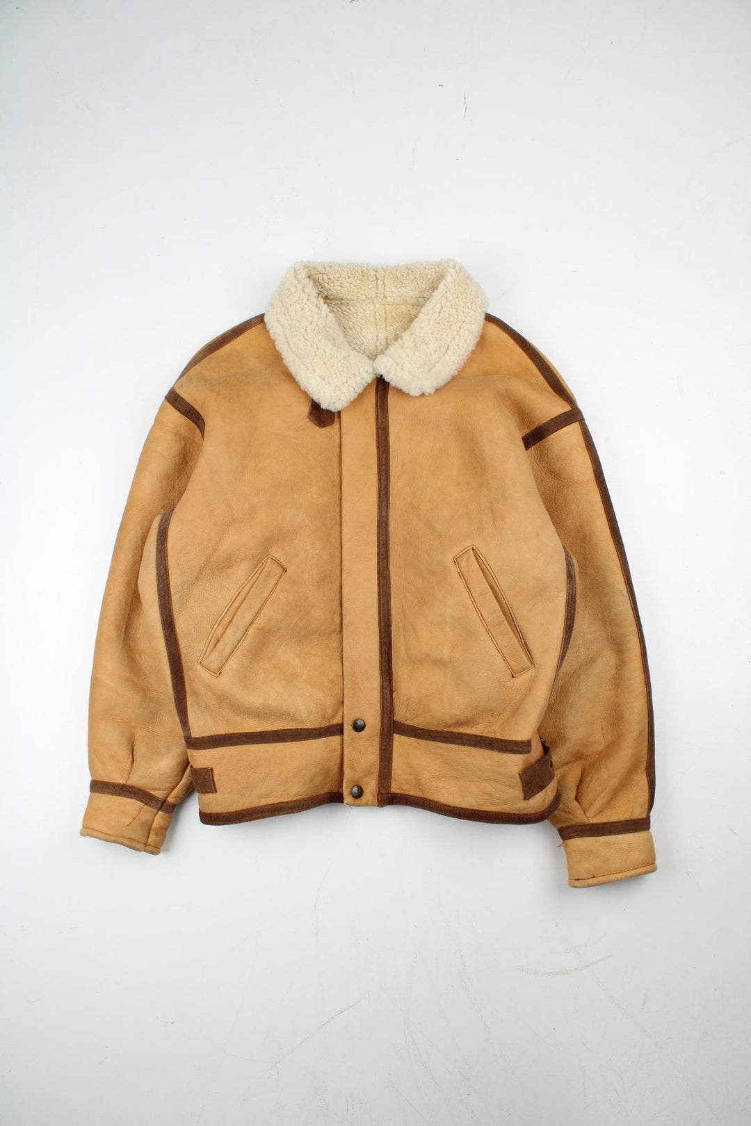 Vintage Shearling Aviator Jacket in a tan colourway, with contrast brown piping. Zip up fastening with side pockets, buckle details and shearling lining.