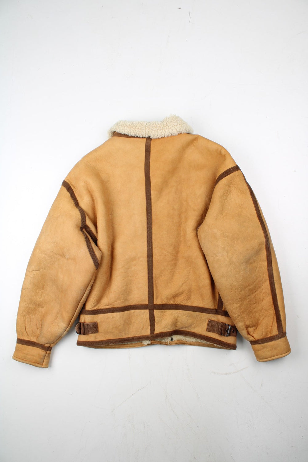 Vintage Shearling Aviator Jacket in a tan colourway, with contrast brown piping. Zip up fastening with side pockets, buckle details and shearling lining.