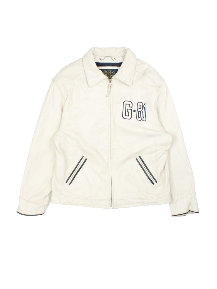 Vintage Guess 1981 Leather Jacket in a tan colourway. Full zip up with double pocket on the front. Varsity style lettering on the front and graphic on the back.
