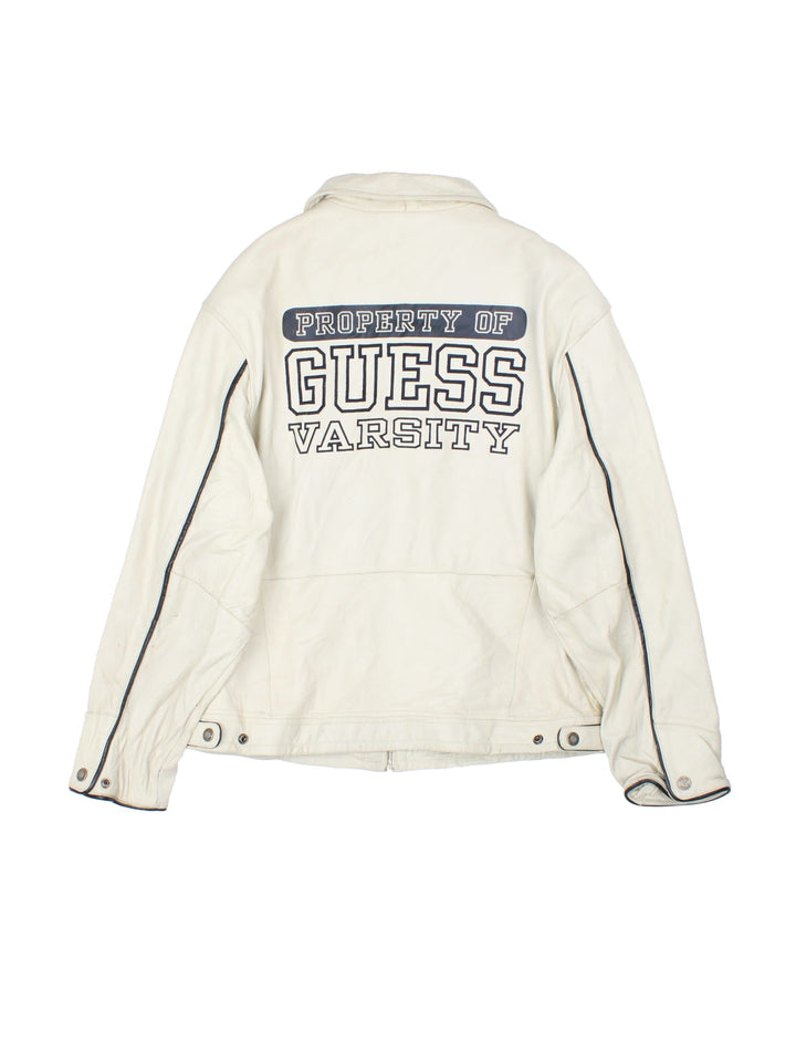 Vintage Guess 1981 Leather Jacket in a tan colourway. Full zip up with double pocket on the front. Varsity style lettering on the front and graphic on the back.
