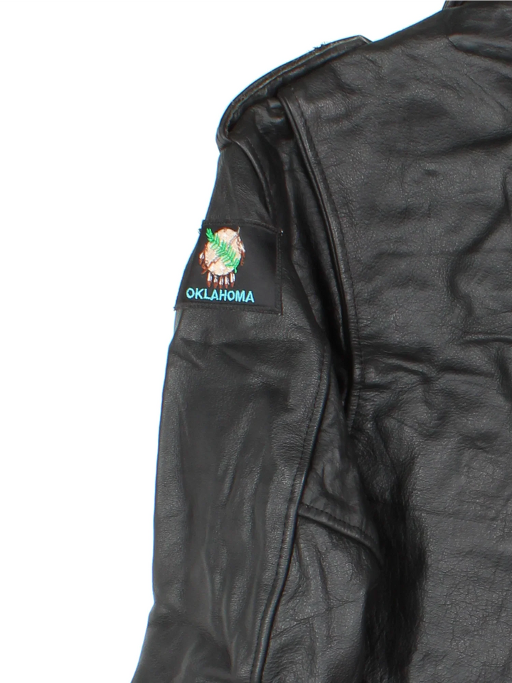 Vintage Leather Biker Jacket in a black colourway. Zips up and has multiple pockets and Oklahoma badge on the left sleeve.