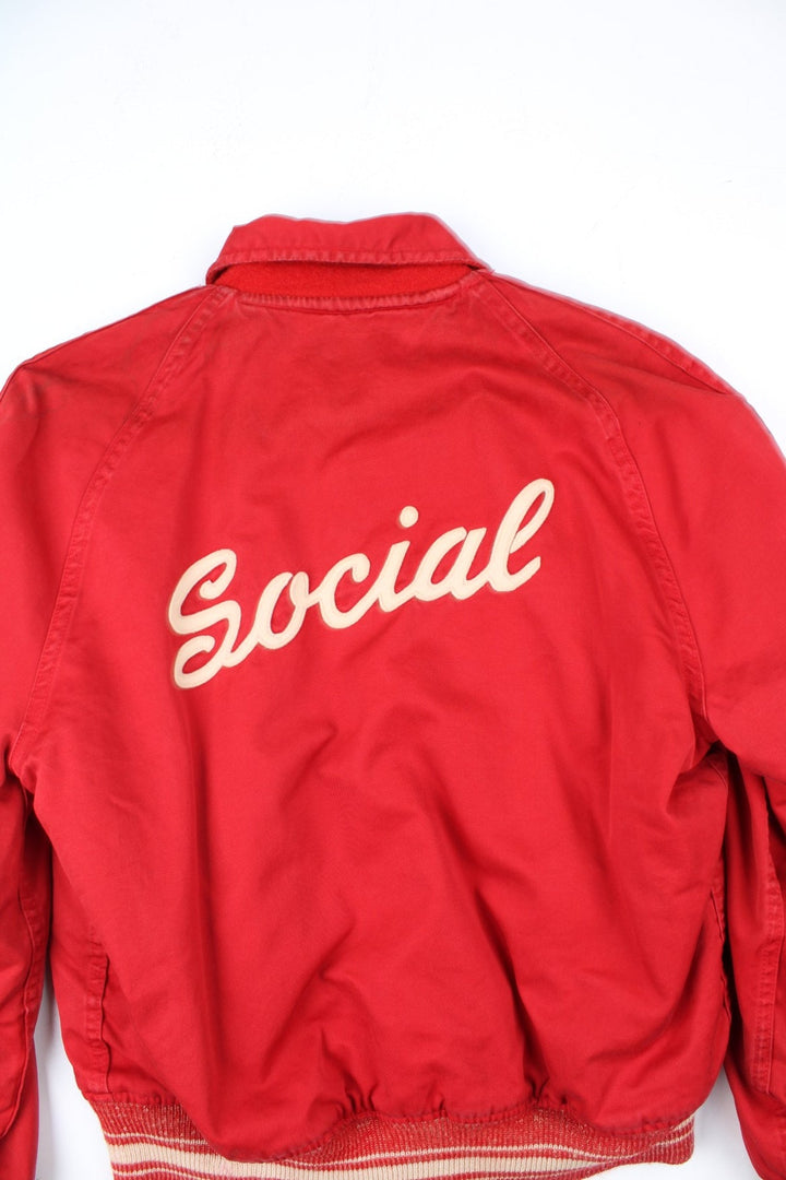 Vintage 70's Reversible Varsity Jacket in a red colourway with either canvas or woolen reversible options. Zips up and has side pockets, and has 'American Turner Social' logo embroidered on the front and back.