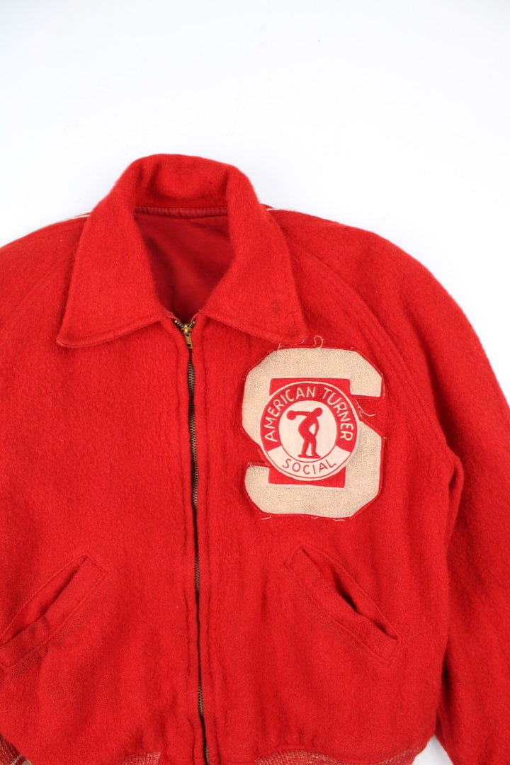 Vintage 70's Reversible Varsity Jacket in a red colourway with either canvas or woolen reversible options. Zips up and has side pockets, and has 'American Turner Social' logo embroidered on the front and back.