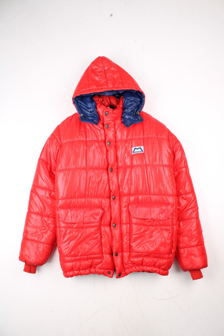 Vintage 80's Mountain Equipment Cerro Torre Puffer Coat in a red colourway. Zips and buttons up, has double front pockets, insulated lining, detachable hood, and has the logo embroidered on the front.