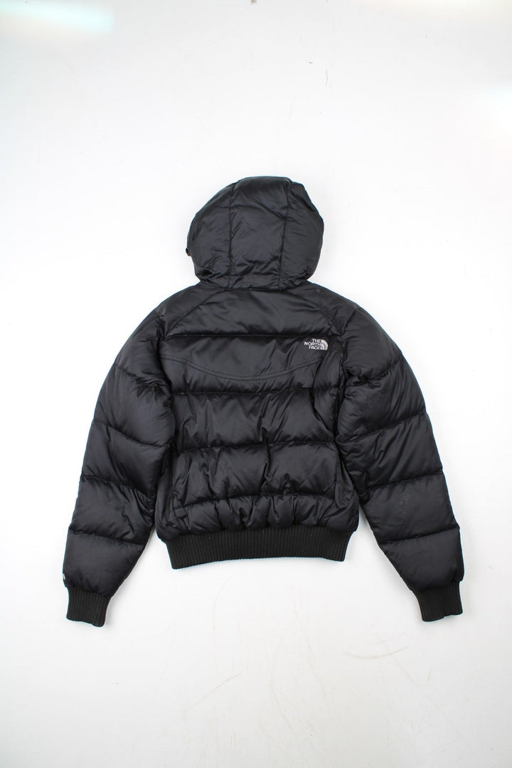 The North Face 550 Down Puffer Jacket in a black colourway. Zips up and has side pockets, insulated lining, hooded, and has the logo embroidered on the front and back.