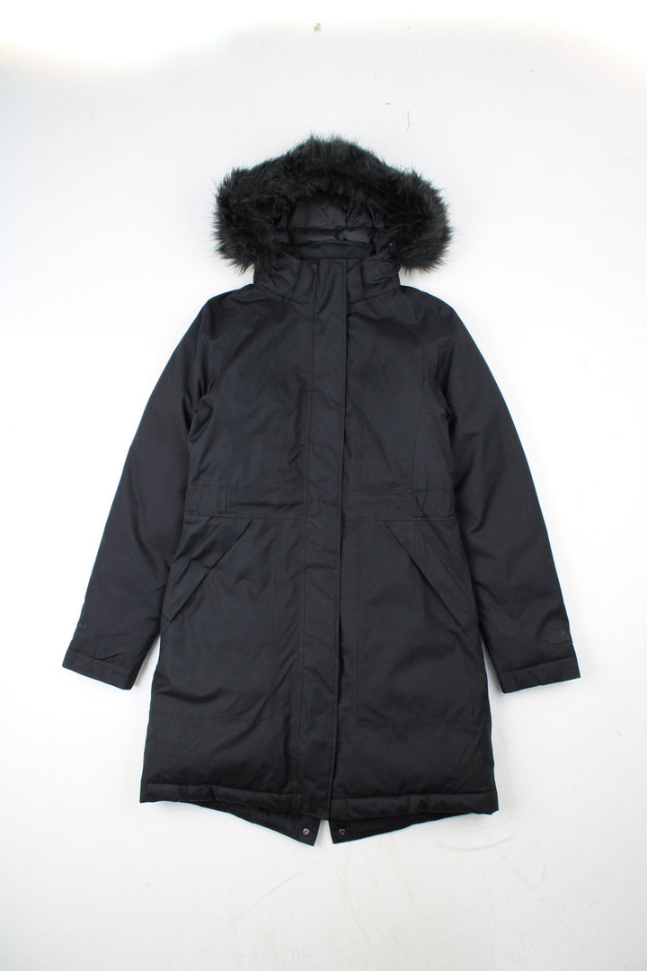 The North Face Jacket in a black colourway. Zips up and has side pockets, insulated lining, hooded with a faux fur trim, and has the logos embroidered on the left sleeve.