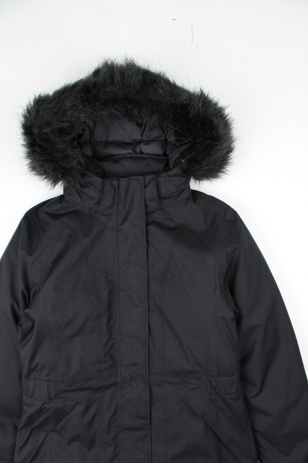 The North Face Jacket in a black colourway. Zips up and has side pockets, insulated lining, hooded with a faux fur trim, and has the logos embroidered on the left sleeve.
