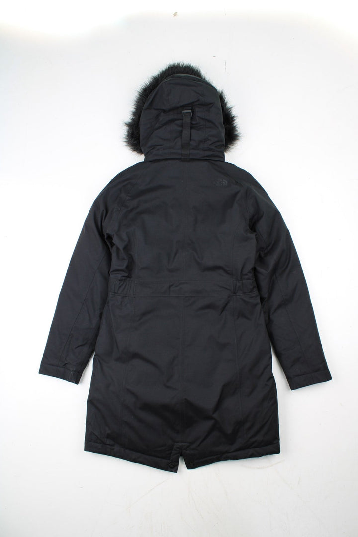 The North Face Jacket in a black colourway. Zips up and has side pockets, insulated lining, hooded with a faux fur trim, and has the logos embroidered on the left sleeve.