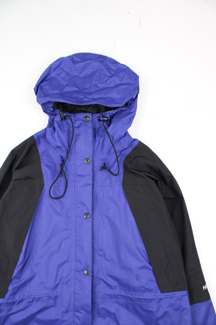 Vintage The North Face Mountain Light Jacket in a purple and black colourway. Zips and buttons up, has side pockets, hooded, and has the logo embroidered on the left sleeve.