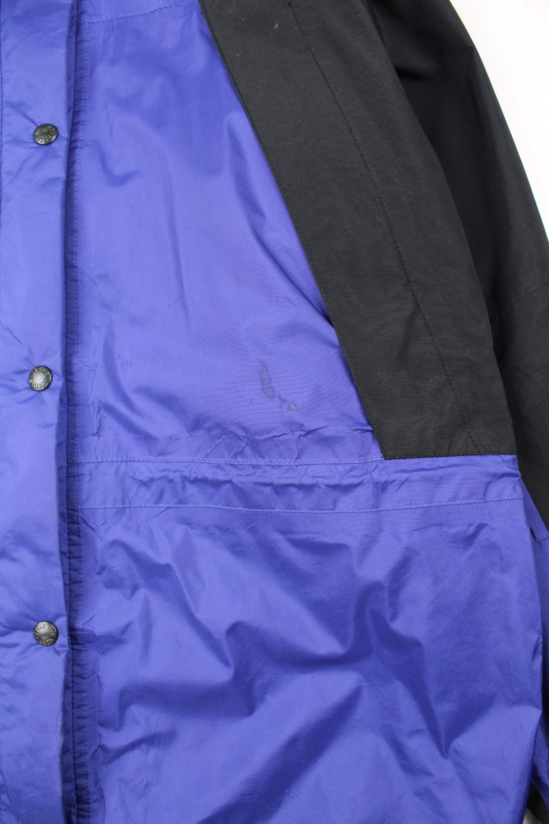 Vintage The North Face Mountain Light Jacket in a purple and black colourway. Zips and buttons up, has side pockets, hooded, and has the logo embroidered on the left sleeve.