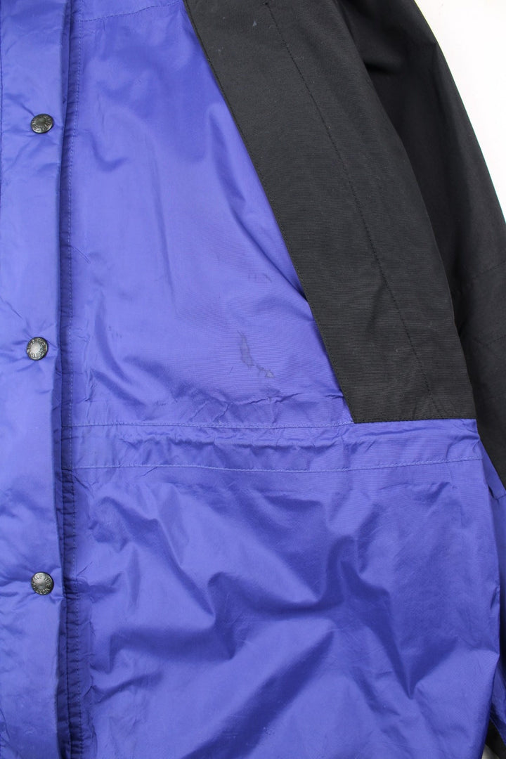 Vintage The North Face Mountain Light Jacket in a purple and black colourway. Zips and buttons up, has side pockets, hooded, and has the logo embroidered on the left sleeve.
