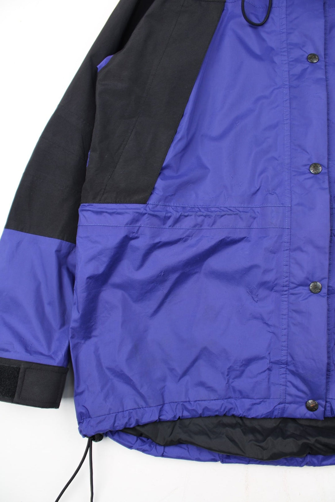 Vintage The North Face Mountain Light Jacket in a purple and black colourway. Zips and buttons up, has side pockets, hooded, and has the logo embroidered on the left sleeve.