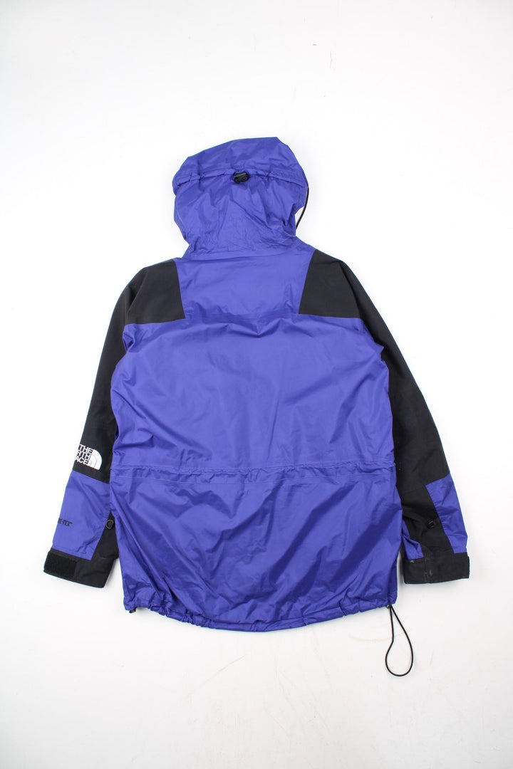 Vintage The North Face Mountain Light Jacket in a purple and black colourway. Zips and buttons up, has side pockets, hooded, and has the logo embroidered on the left sleeve.