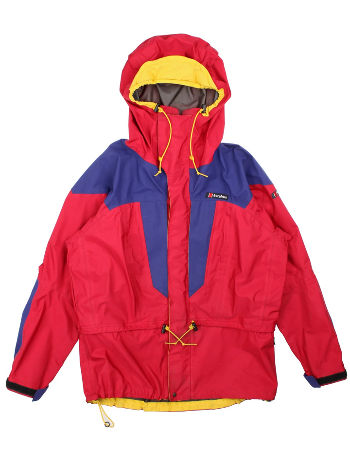 Vintage 90's Berghaus Manaslu Gore-Tex Coat in a red/blue colourway, zips up and has multiple pockets, hooded, insulated with a Gore-tex lining, and has the logo embroidered on the front.
