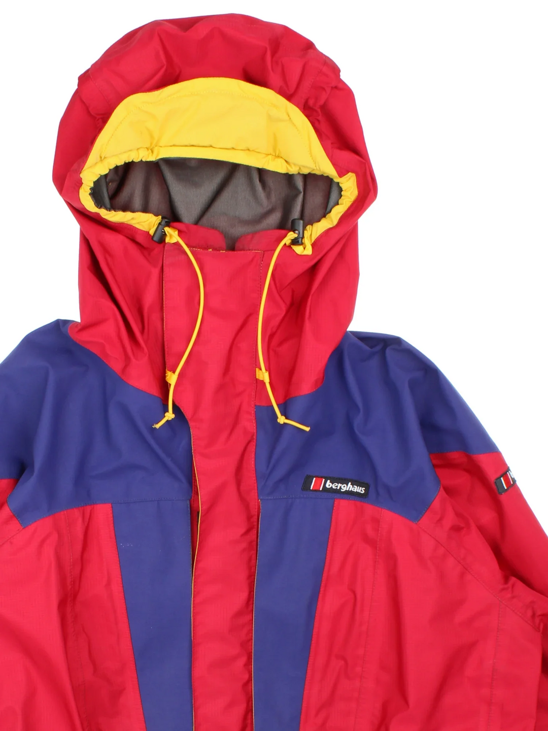 Vintage 90's Berghaus Manaslu Gore-Tex Coat in a red/blue colourway, zips up and has multiple pockets, hooded, insulated with a Gore-tex lining, and has the logo embroidered on the front.