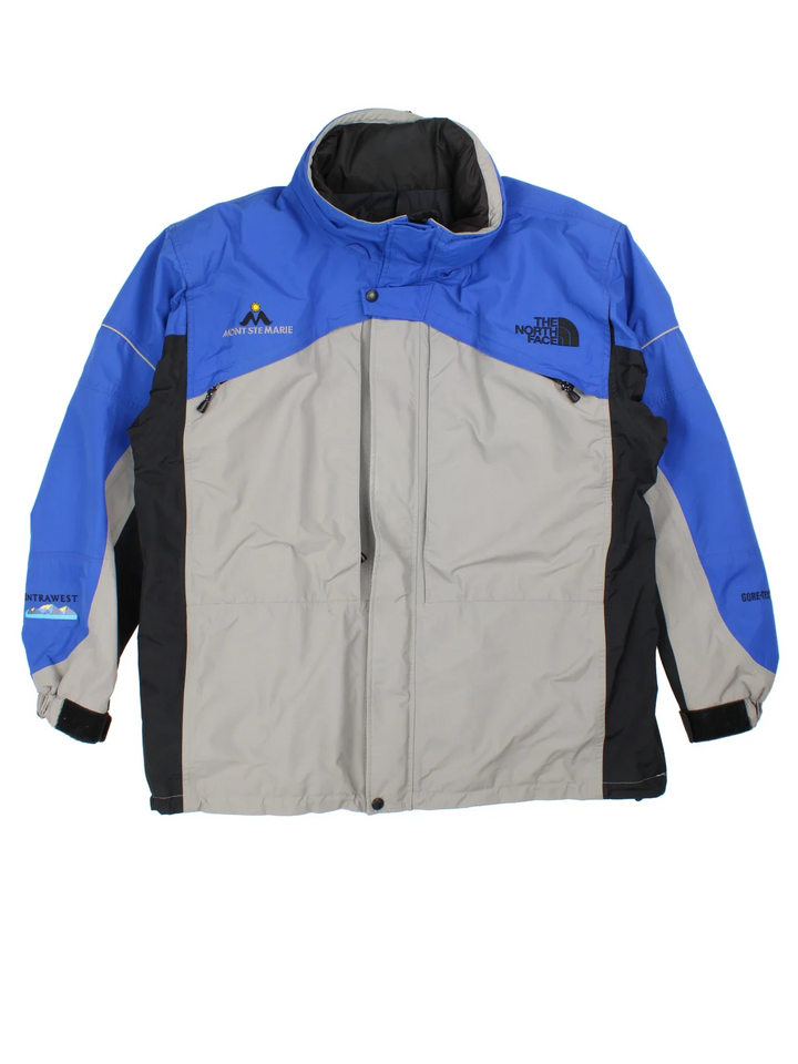 Vintage The North Face Mountain Ski Jacket in a blue/grey colourway. Zip fastening with hood and multiple zip pockets. Drawstring hem, mesh lining and has the logo embroidered on the front/back.