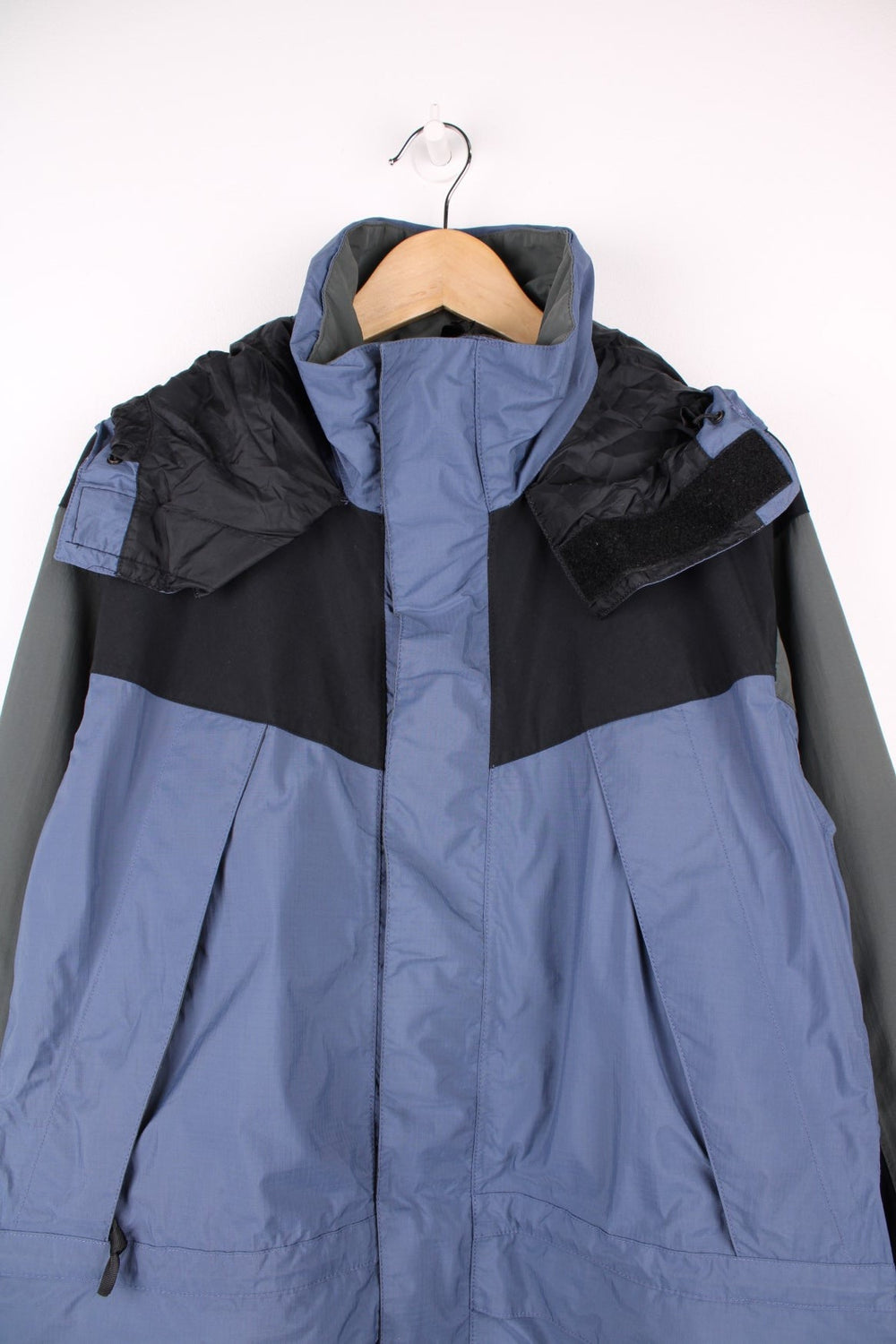 The North Face Hydroseal blue and grey zip through waterproof jacket. Features multiple pockets, foldaway hood and embroidered logo on the sleeve