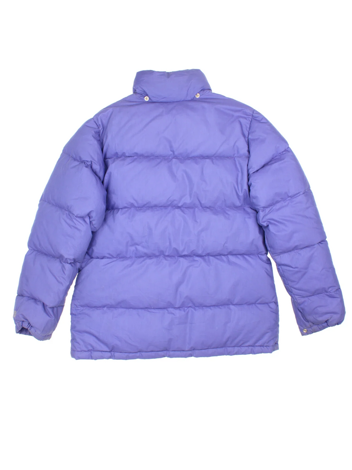 The North Face Puffer Coat in a purple colourway, full zip up and button up and has multiple pockets, hooded and has the logo embroidered on the front.
