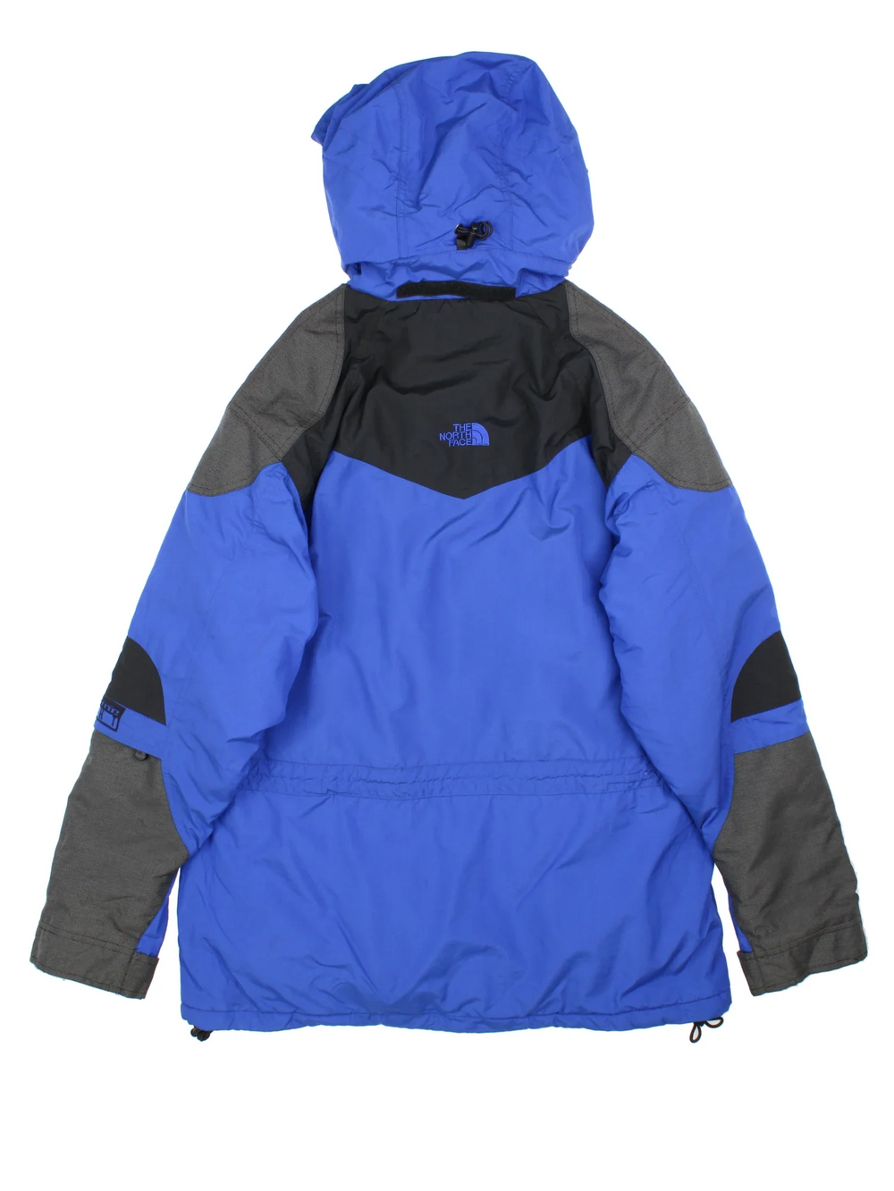 The North Face Coat in a blue colourway with black panelling, full zip up and button up. multiple pockets and has the logo embroidered on the sleeve and front.