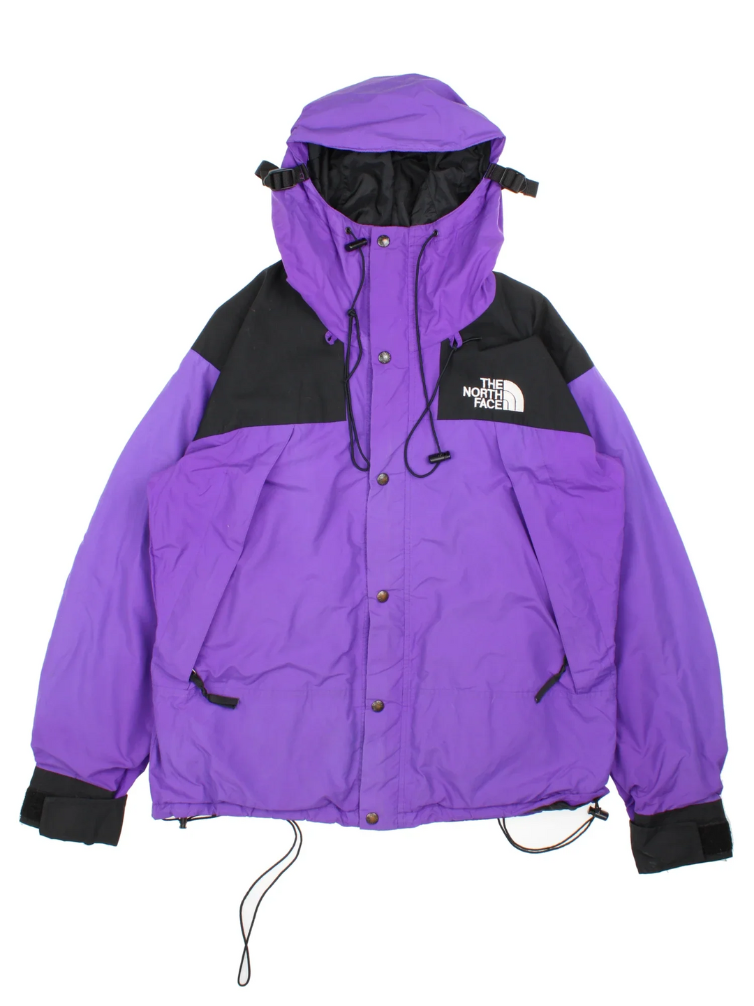 The North Face Gore-Tex Mountain Jacket in a purple colourway with black panelling, full zip up and button up. multiple pockets, hood, drawstring hem and has the logo embroidered on the sleeve and front.