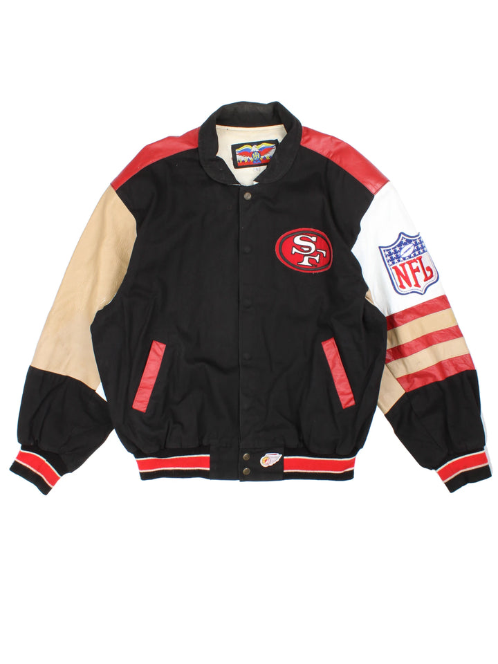 San Francisco 49s, NFL, Jeff Hamilton bomber-style pro sport jacket in a black colourway with white, red and tan detail. Zip closure with team logos embroidered on the front and back.