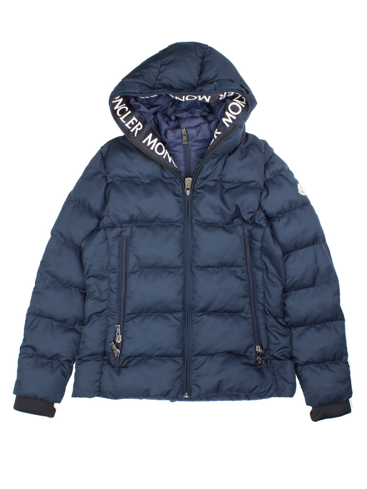 Moncler Cardere down puffer coat in a navy blue colourway. The coat has a puffer lining and the Moncler logo embroidered around the collar. There are extra thermal lined cuffs and a double zip for extra warmth.  
