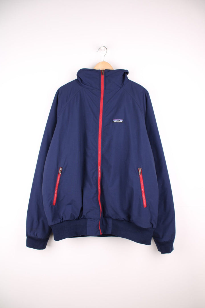 Patagonia zip through fleece lined jacket in blue and red. Features embroidered logo on the chest.