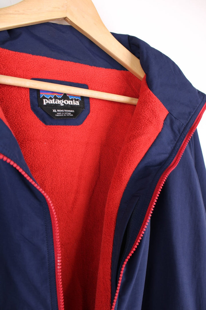 Patagonia zip through fleece lined jacket in blue and red. Features embroidered logo on the chest.