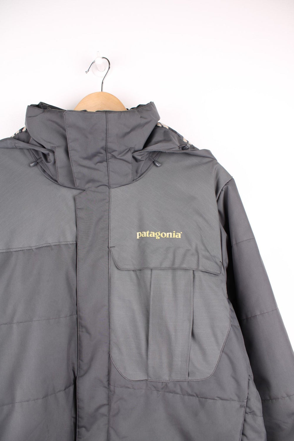 Patagonia puffer coat with printed logo on the chest and sleeve, multiple pockets and removable hood. 