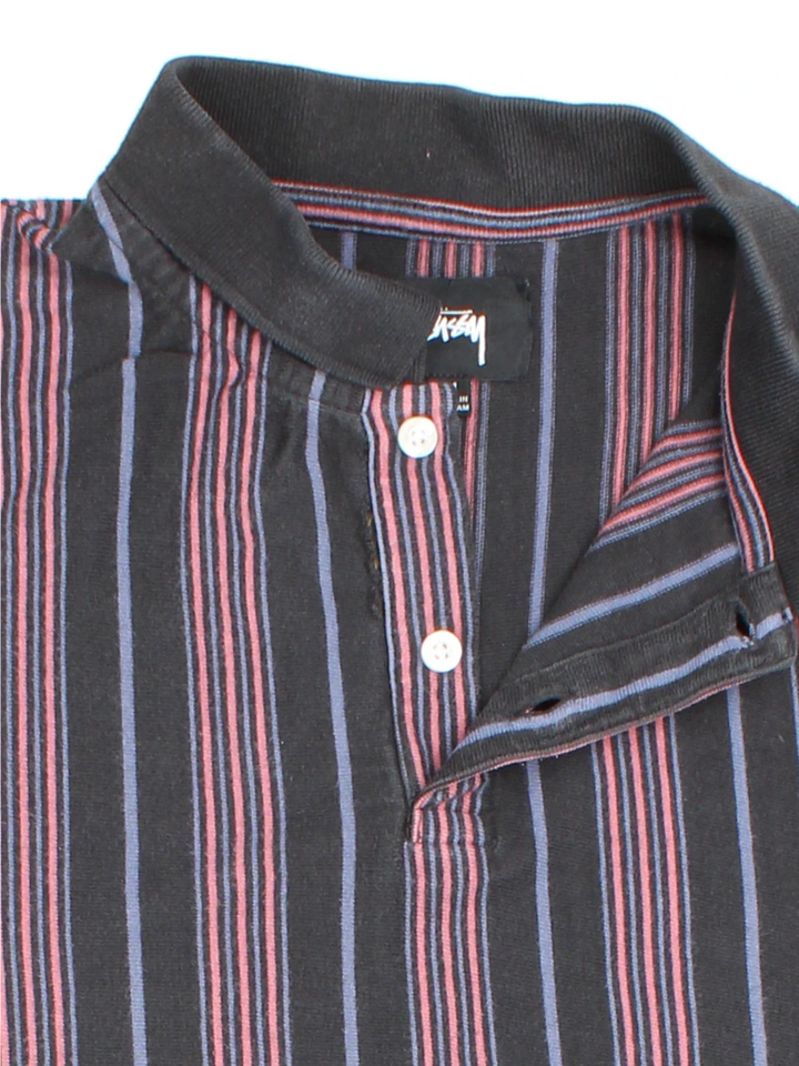 Stussy Revival Stripe Polo Shirt in a grey, black and pink colourway, button up collar with the logo embroidered on the front by the hem.