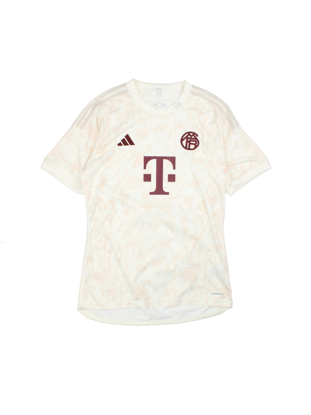 FC Bayern 2023/24 Adidas third kit football shirt in tan with subtle floral print, three stripe detailing in white, and logos and a badge on the front.