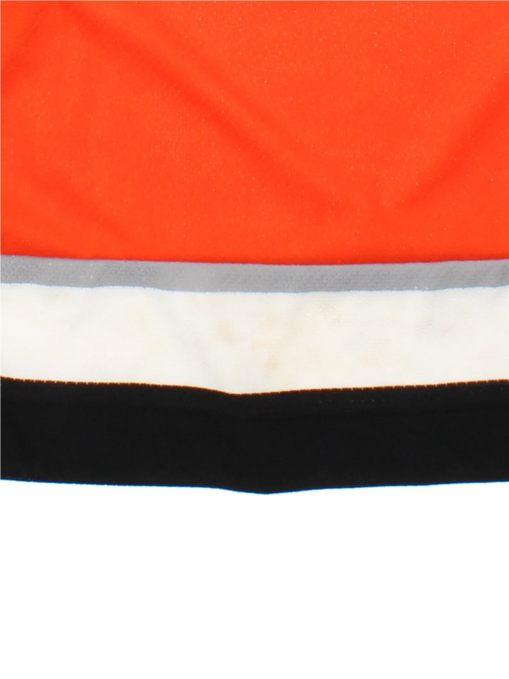 Philadelphia Flyers NHL Jersey in a  orange colourway, features embroidered logos and badge on the front with black and white stripe detailing on the sleeves and hem.