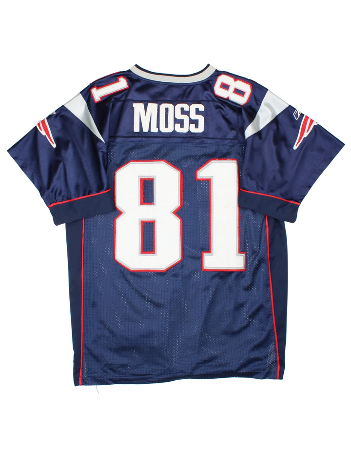New England Patriots Reebok NFL Jersey in the blue home kit colourway with silver and red detailing, features embroidered logos and badge on the front and player name MOSS #81 on the back.