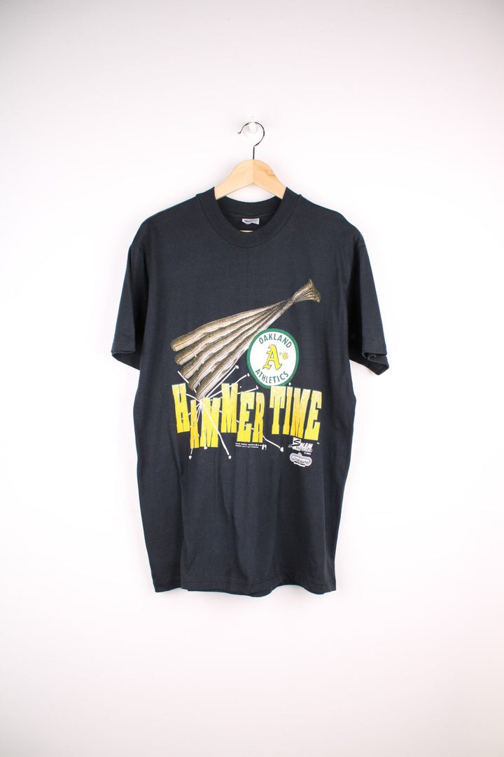 Oakland Athletics MLB t-shirt in black with baseball bat graohic and spellout reading 'Hammer Time' and 'U Can't Touch This' in green and yellow on the front and back.
