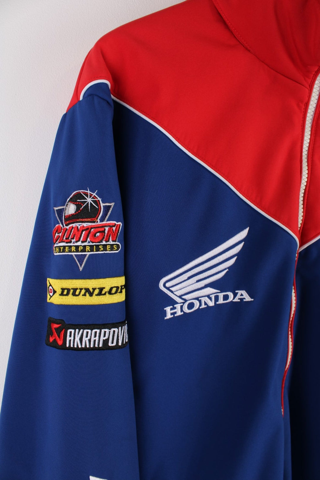  Honda Softshell Racing Jacket in a  and red colourway, zips up and has side pockets, hidden hood, and the logos embroidered all over the jacket.