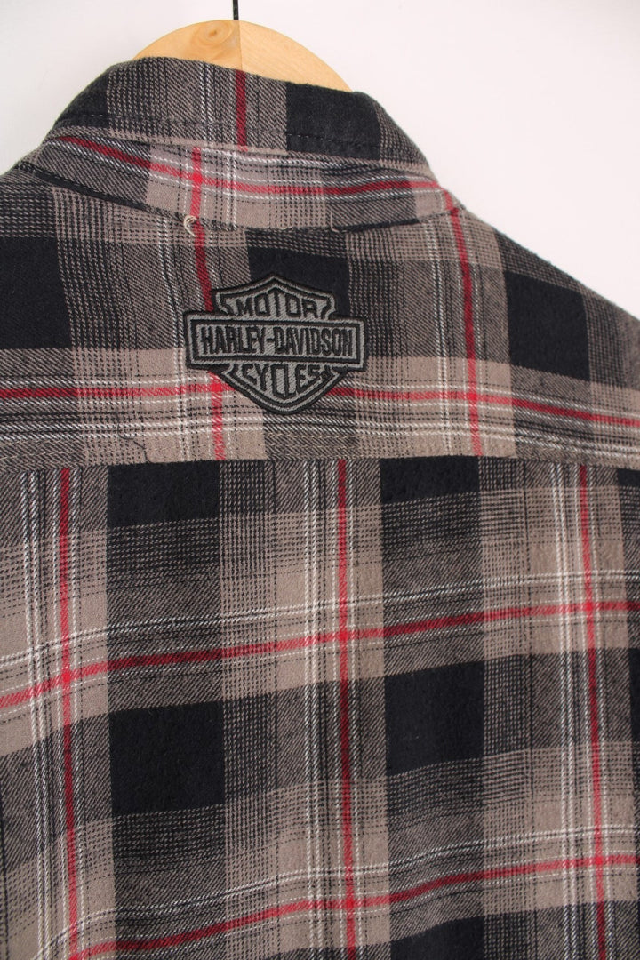  Flannel Style Shacket in a , black and red plaid colourway, buttons up, has multiple pockets, quilted lining and the logo embroidered on the front and back.