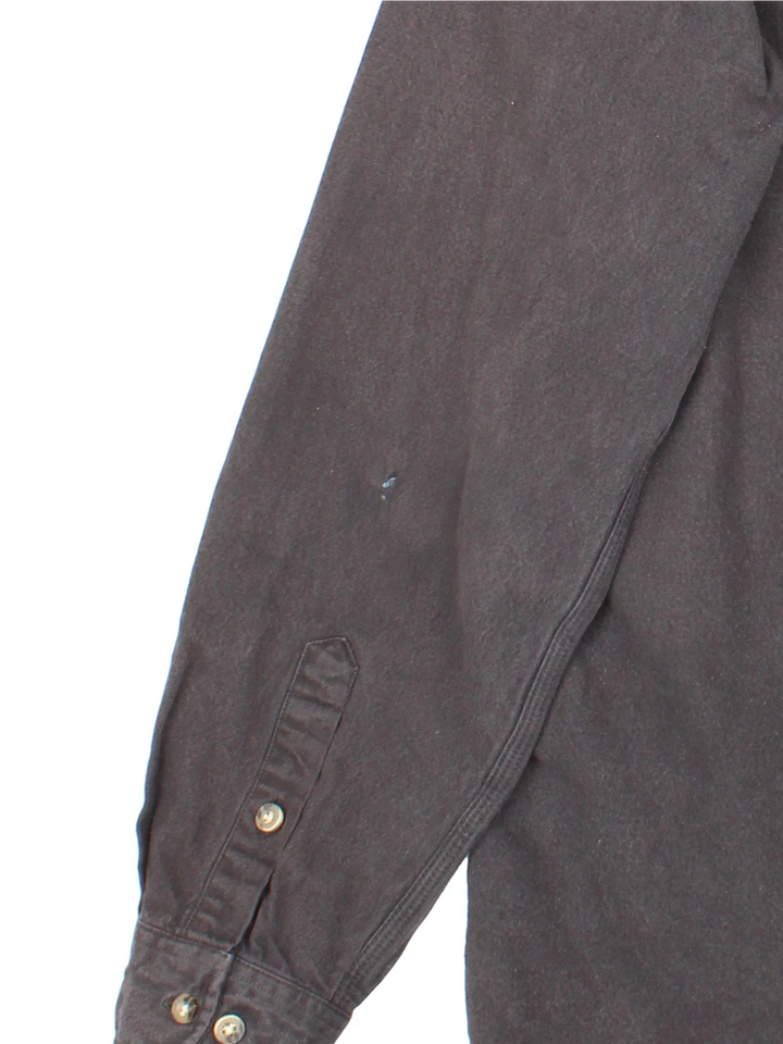 Carhartt Heavy Work Shirt in a black colourway, buttons up and has double chest pockets with the logo embroidered on the front.