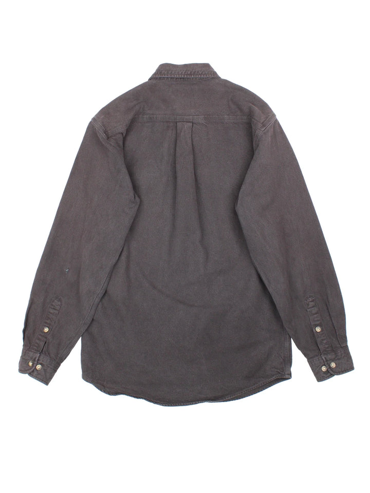 Carhartt Heavy Work Shirt in a black colourway, buttons up and has double chest pockets with the logo embroidered on the front.